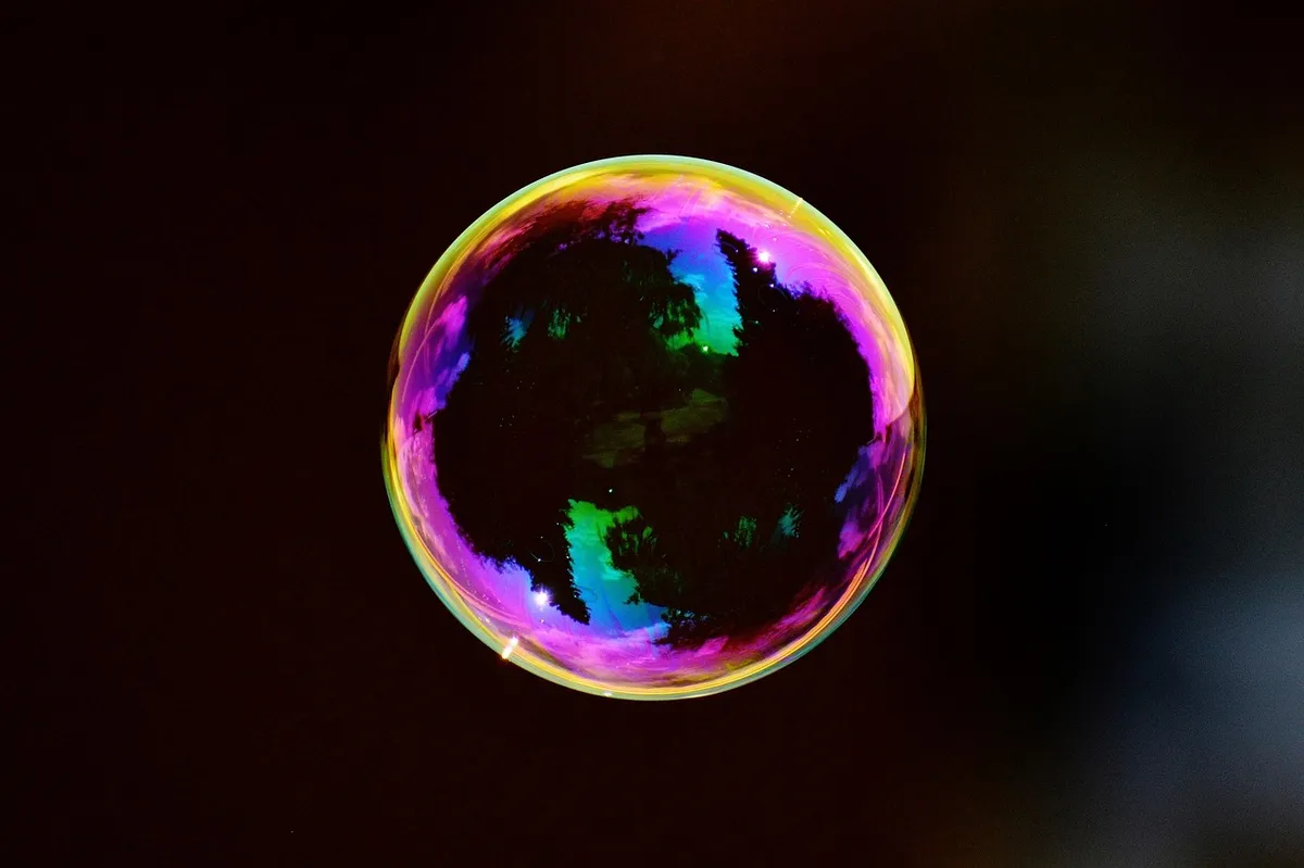 A colorful soap bubble floating against a dark background